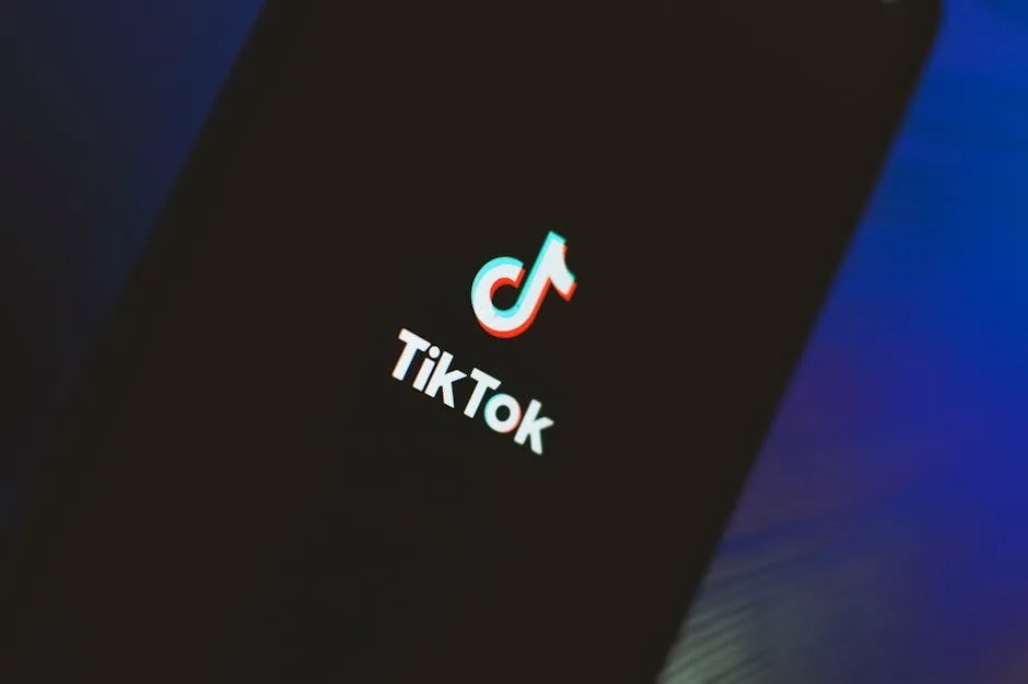 A close-up view of the TikTok app logo illuminated on a smartphone screen.