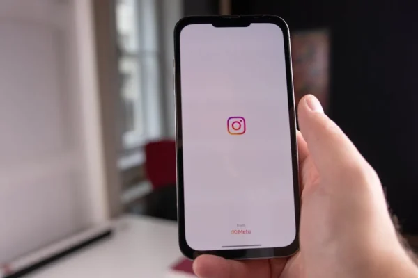Close-up of a hand holding a smartphone displaying the Instagram app, indoors in Budapest.