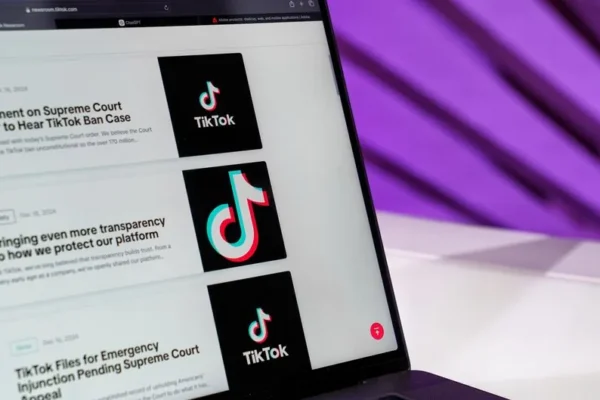 Close-up of laptop screen showing TikTok news articles with a purple background.