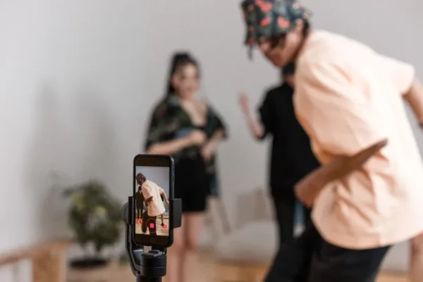 Vibrant indoor scene of people dancing recorded on a smartphone for a social media platform.
